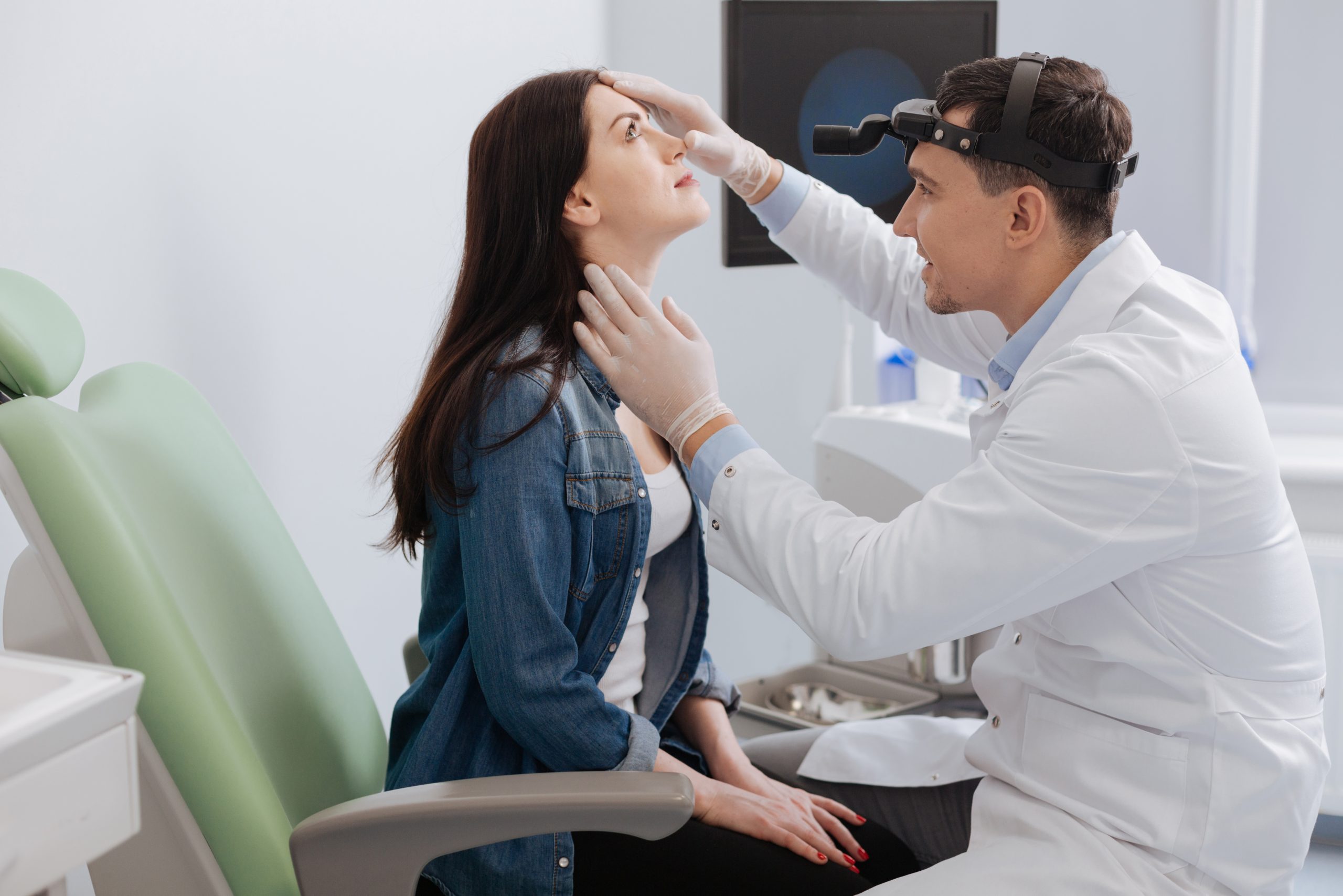 El médico examina la nariz del paciente.
